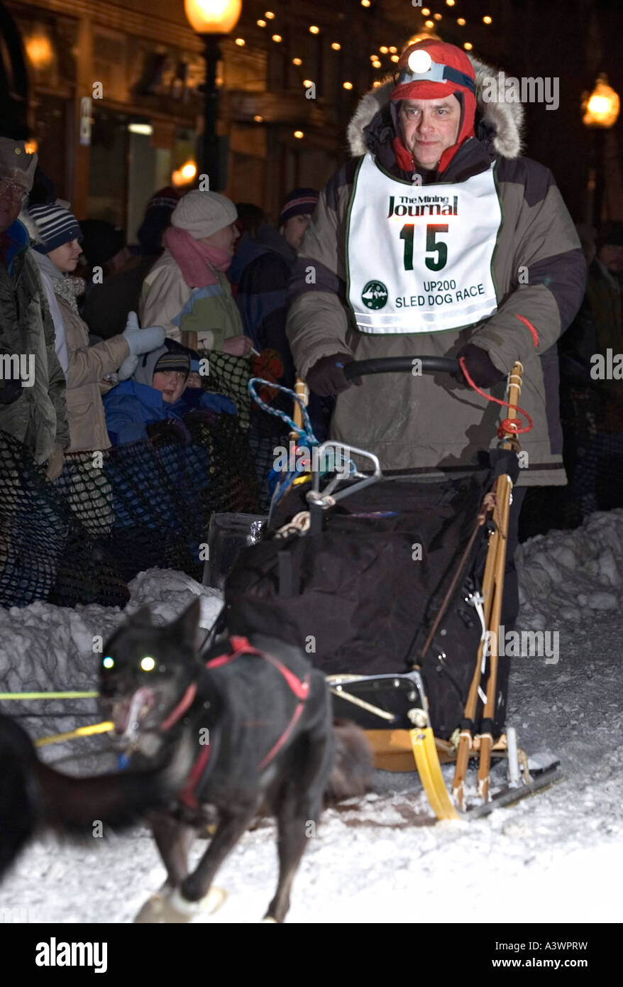 Crowds cheer as a musher rides through historic downtown Marquette Mich during the U P 200 Sled Dog Championship Stock Photo