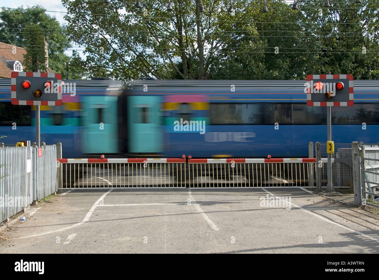 Transport Railway Line Red Flashing Warning Light Sign Level Crossing Barrier Gate Country Road Passenger Train Carriages Motion Blur Essex England Uk Stock Photo Alamy