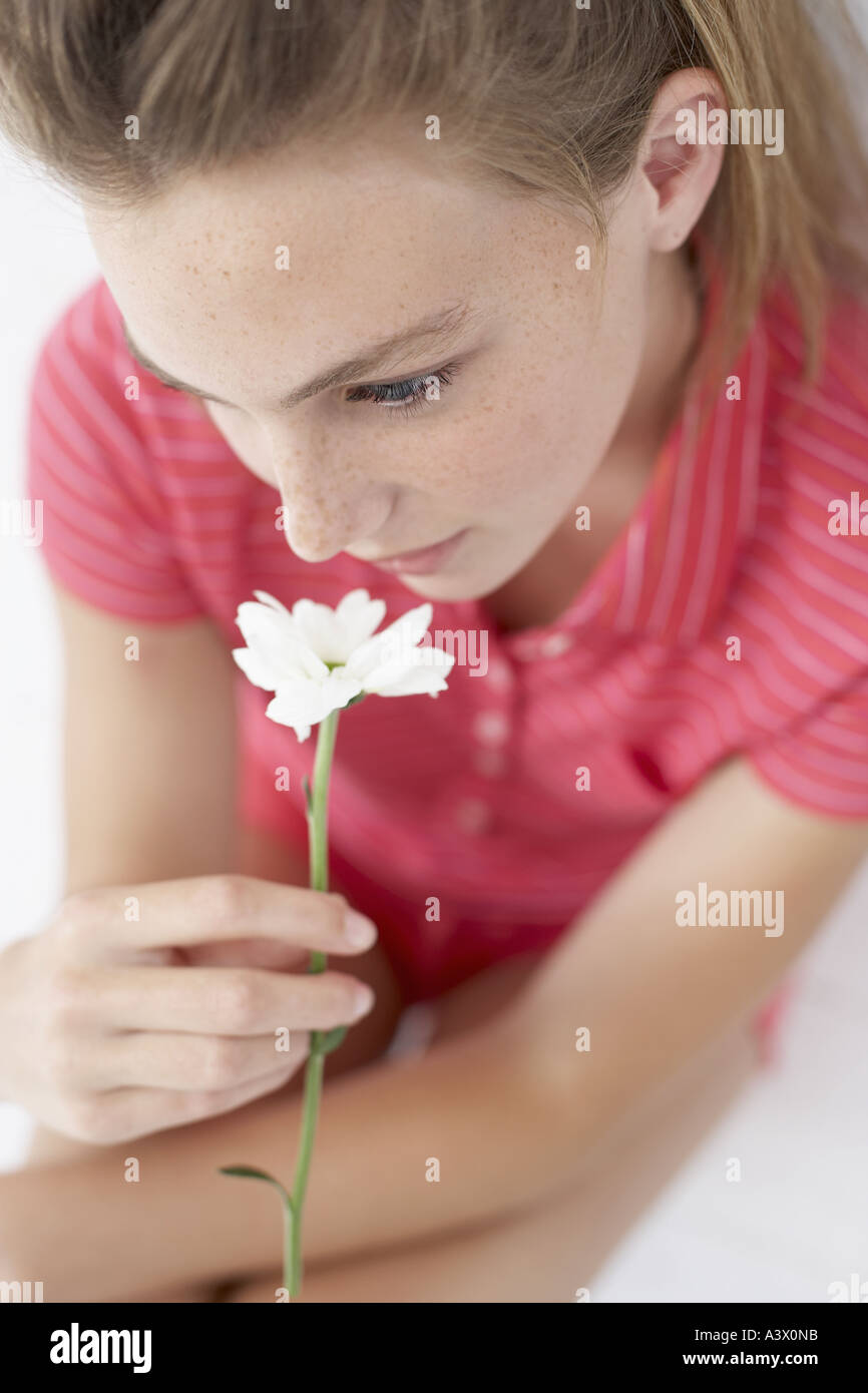A young woman smelling a flower Stock Photo - Alamy