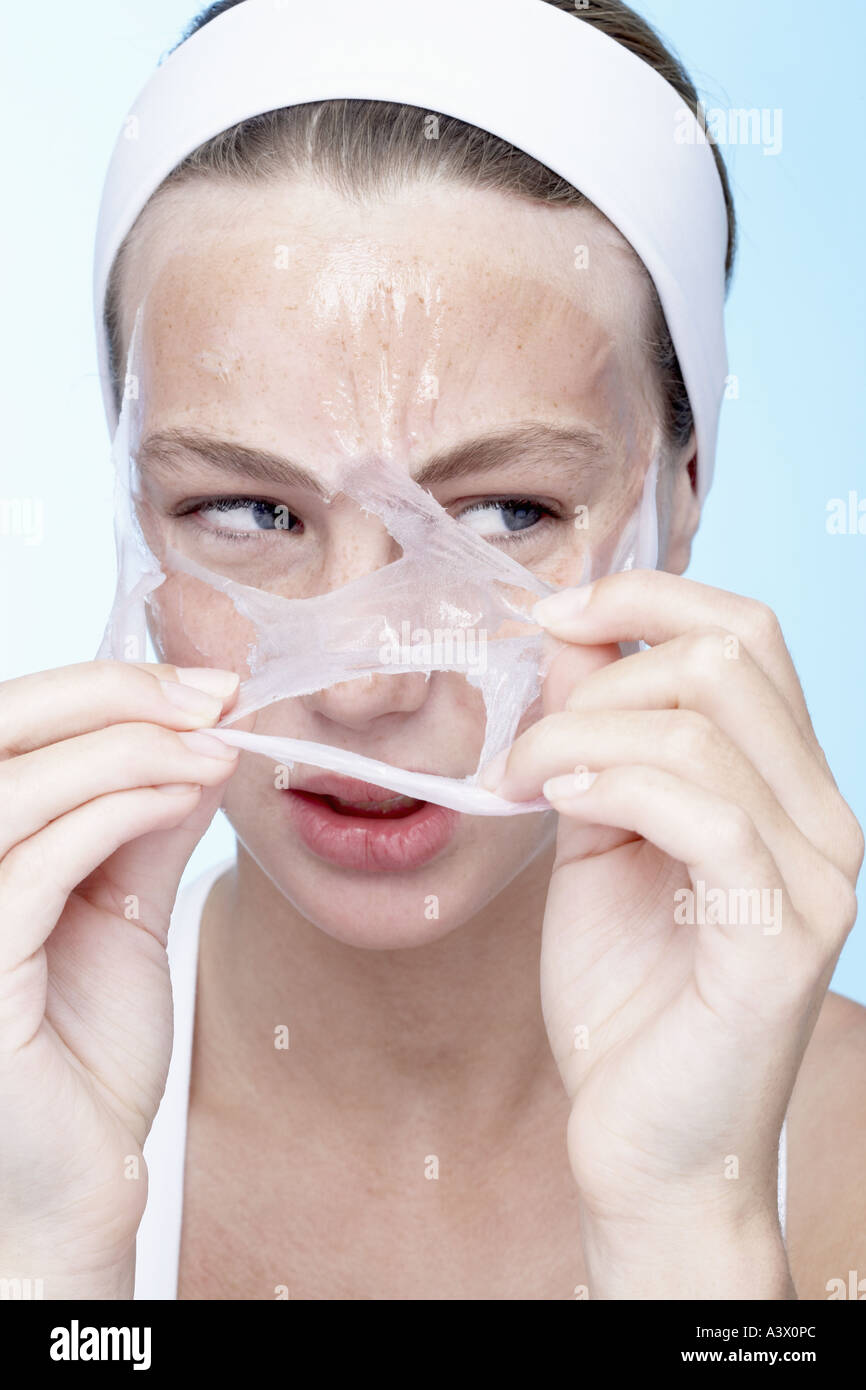 A young woman peeling off a face mask Stock Photo Alamy