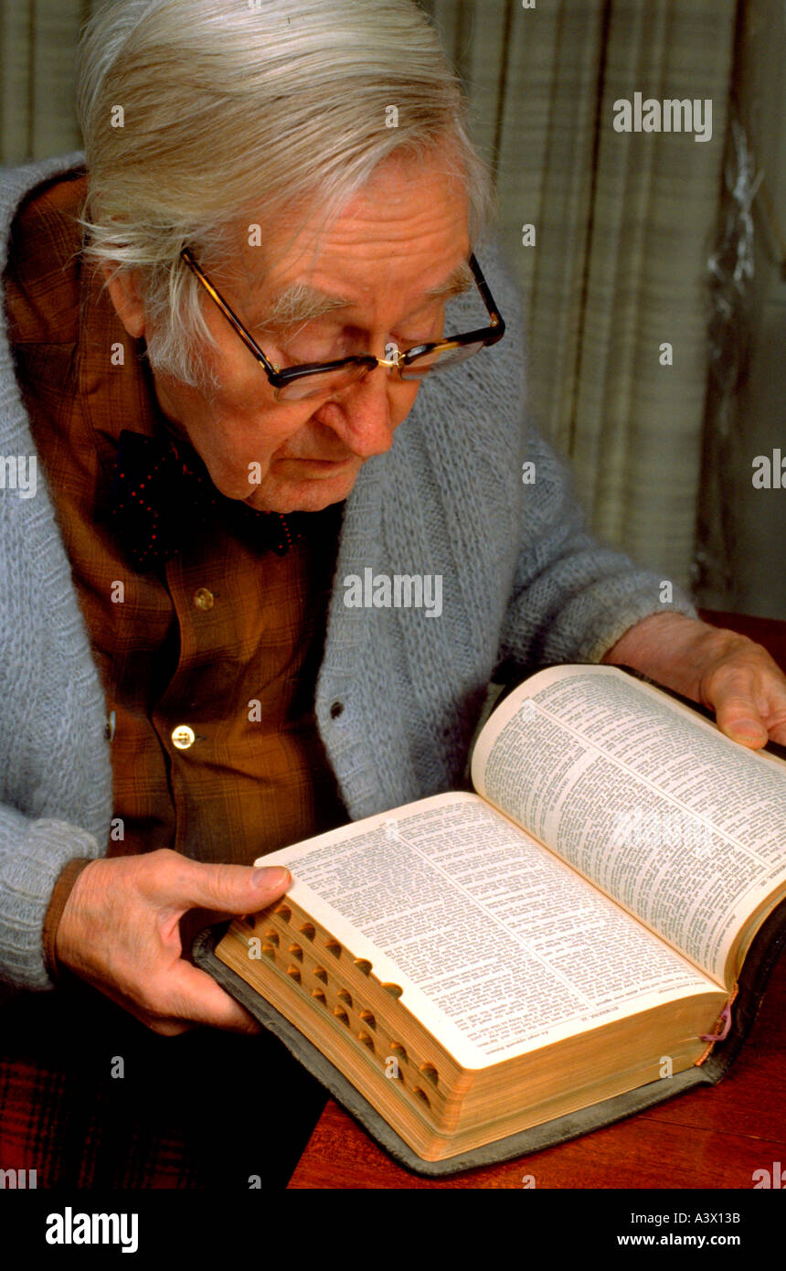 Retired physician age 86 reading Bible in his home. Minneapolis Minnesota USA Stock Photo