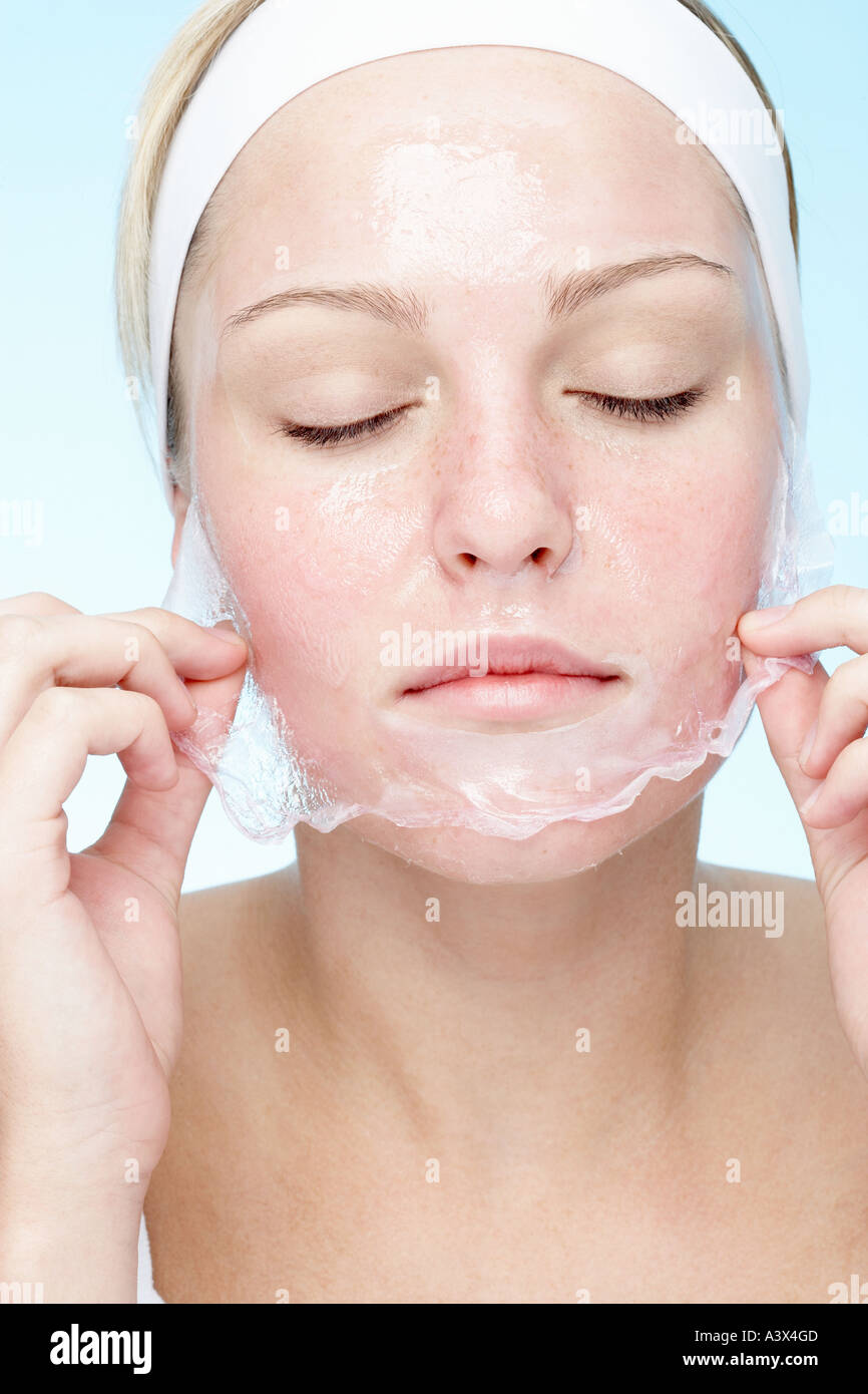 Young woman peeling off her face mask Stock Photo Alamy
