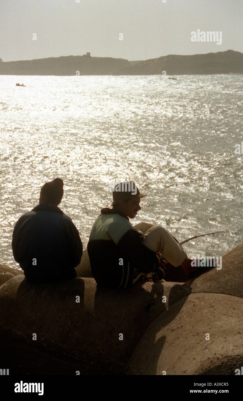 Two silhouetted fishermen Essaouira, Morocco Stock Photo