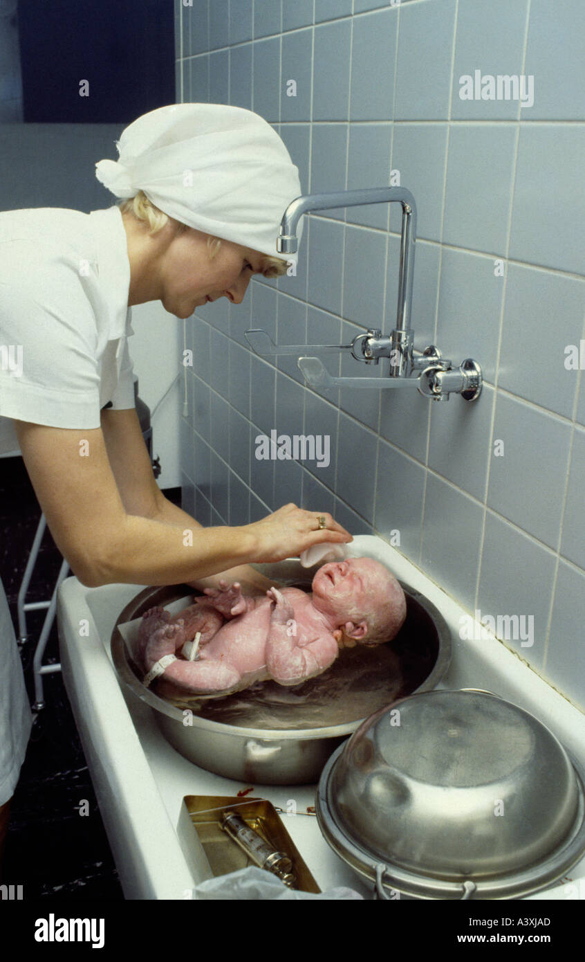 Nurse cleaning and washing a newborn boy. Stock Photo