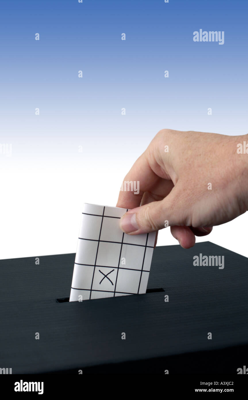 hand placing a vote into a ballot box Stock Photo