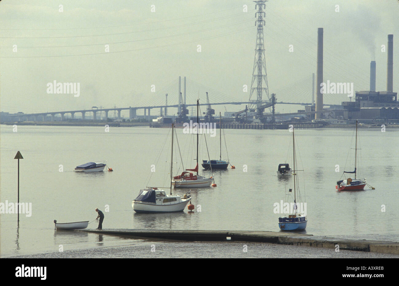 Thames estuary Thurrock Essex England 1990s. A weekend sailor the river The Dartford bridge is in the distance 1991 HOMER SYKES Stock Photo