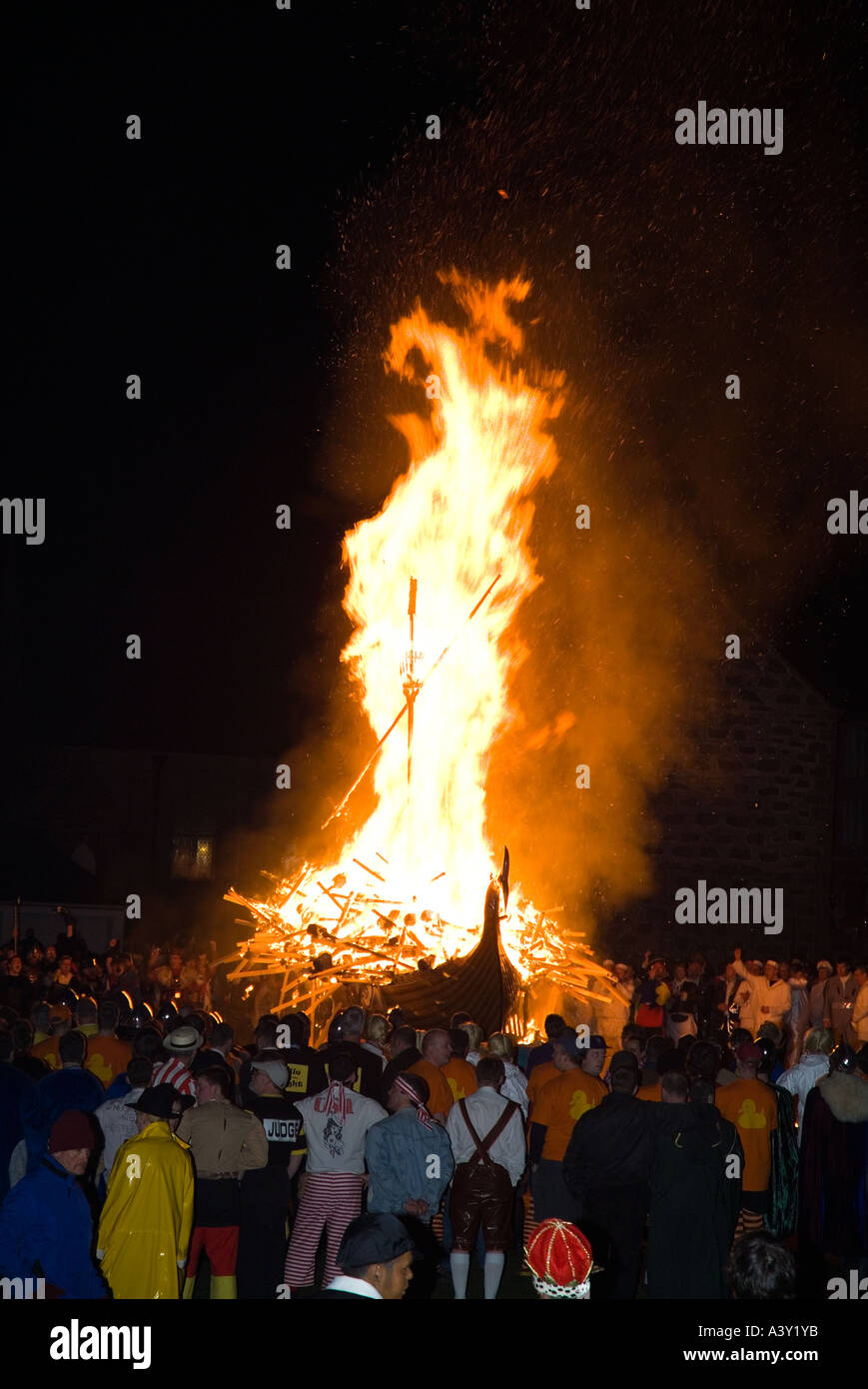 dh Up Helly Aa fire procession LERWICK SHETLAND Guizers watching Viking longship galley Moogi alight at burning site Stock Photo