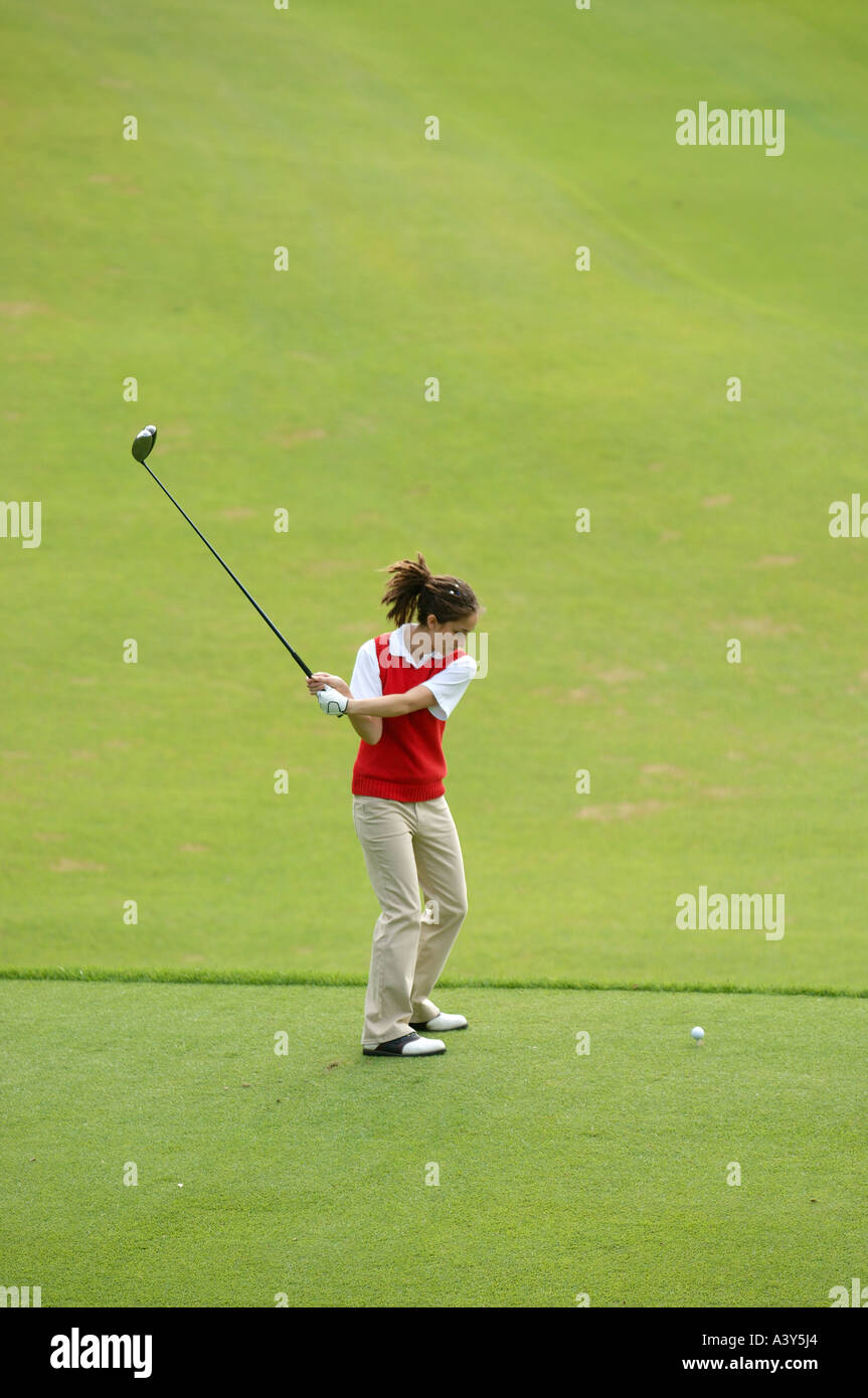 Female golfer taking a swing on the tee ground Stock Photo