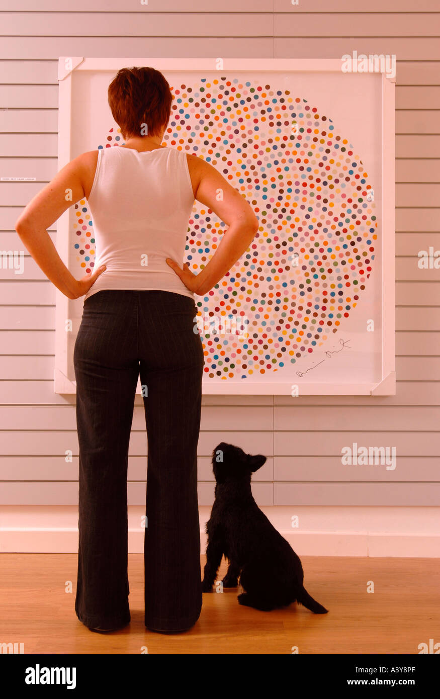 A WOMAN VIEWING A DAMIEN HIRST DOT PAINTING TITLED VALIUM IN AN EYESTORM ART GALLERY Stock Photo