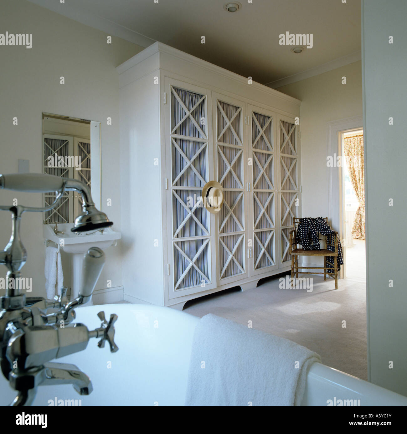 Bathroom cupboard with lattice doors and shower fitting on bath Stock