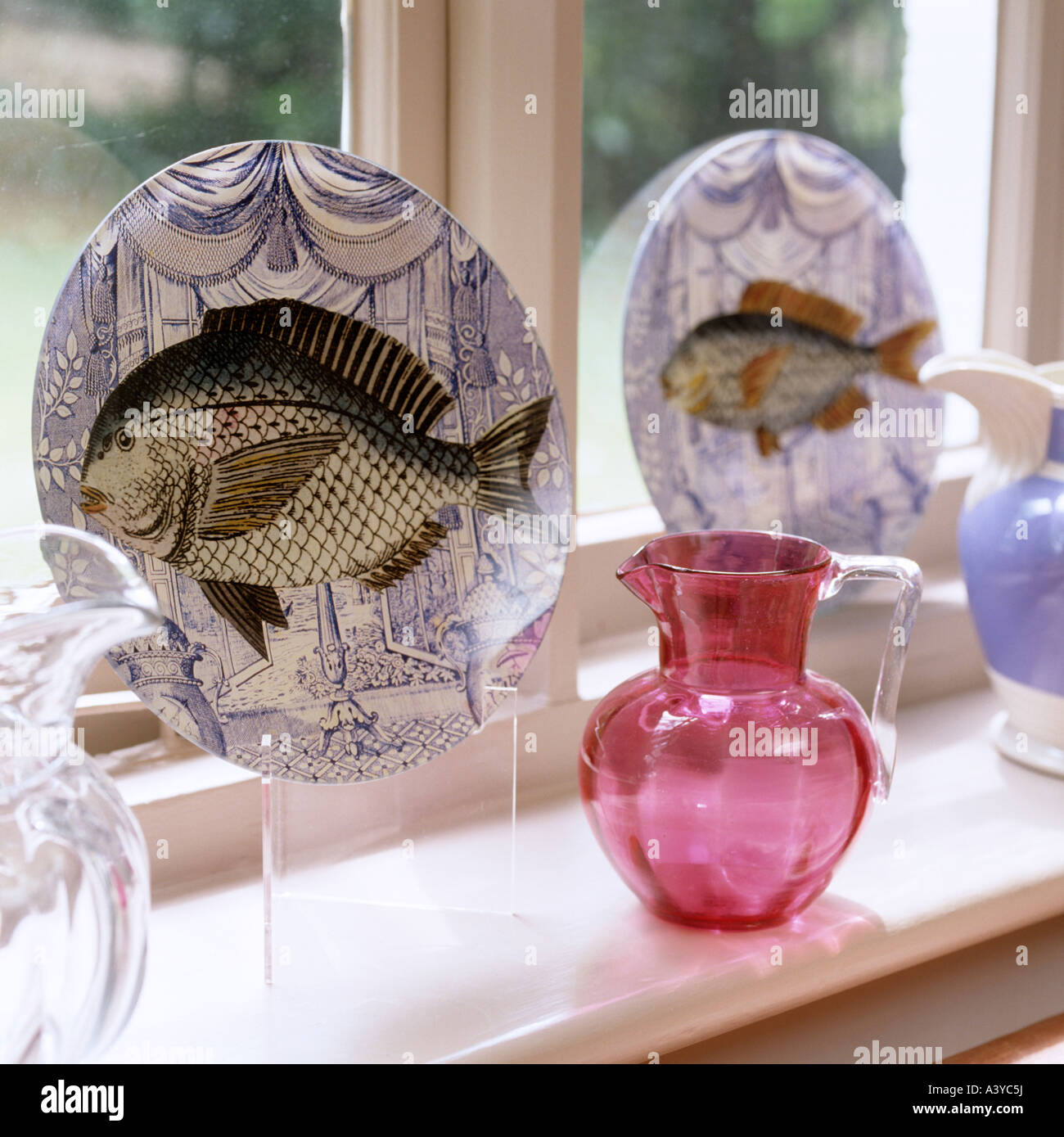 Ornamental plates and jugs on windowsill display Stock Photo Alamy