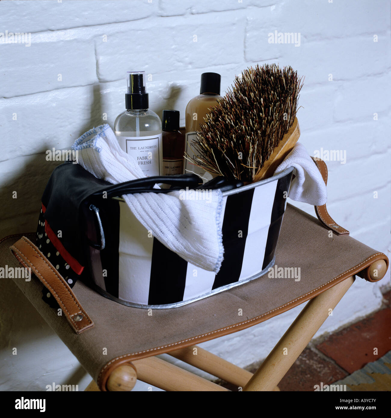 A box of toiletries on a leather folding stool Stock Photo