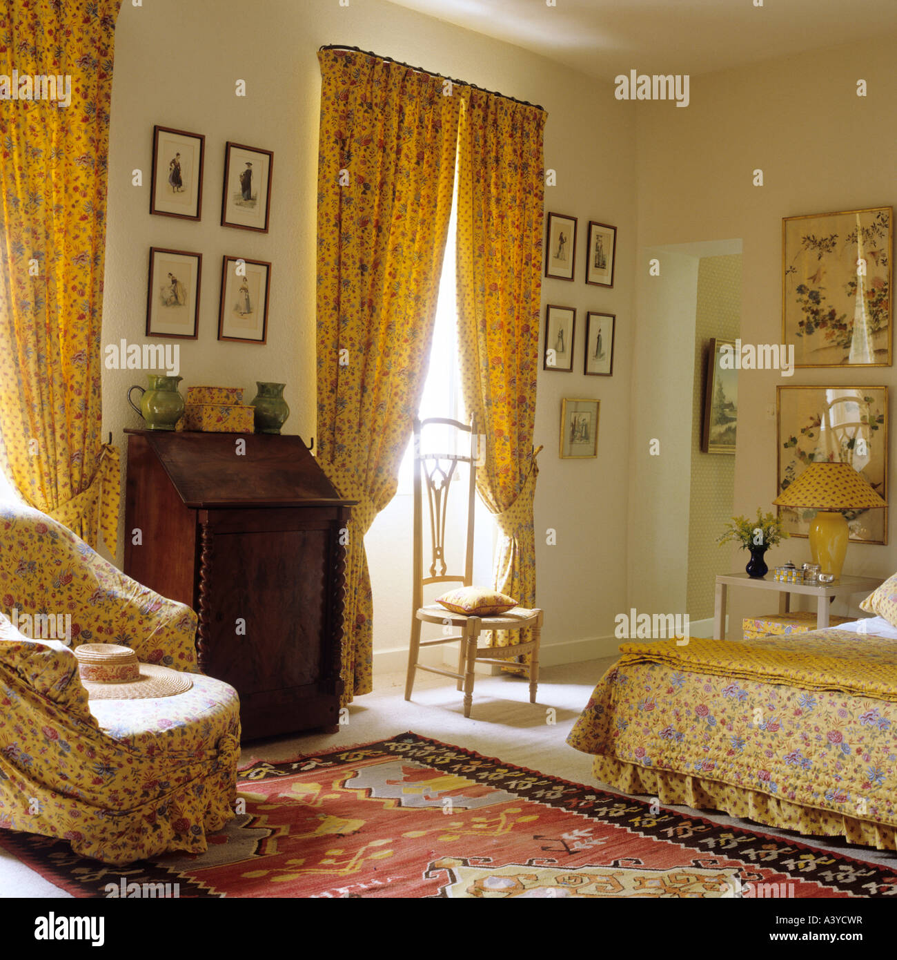 Bedroom with yellow curtains and matching bed cover in a typical Provençal house Stock Photo