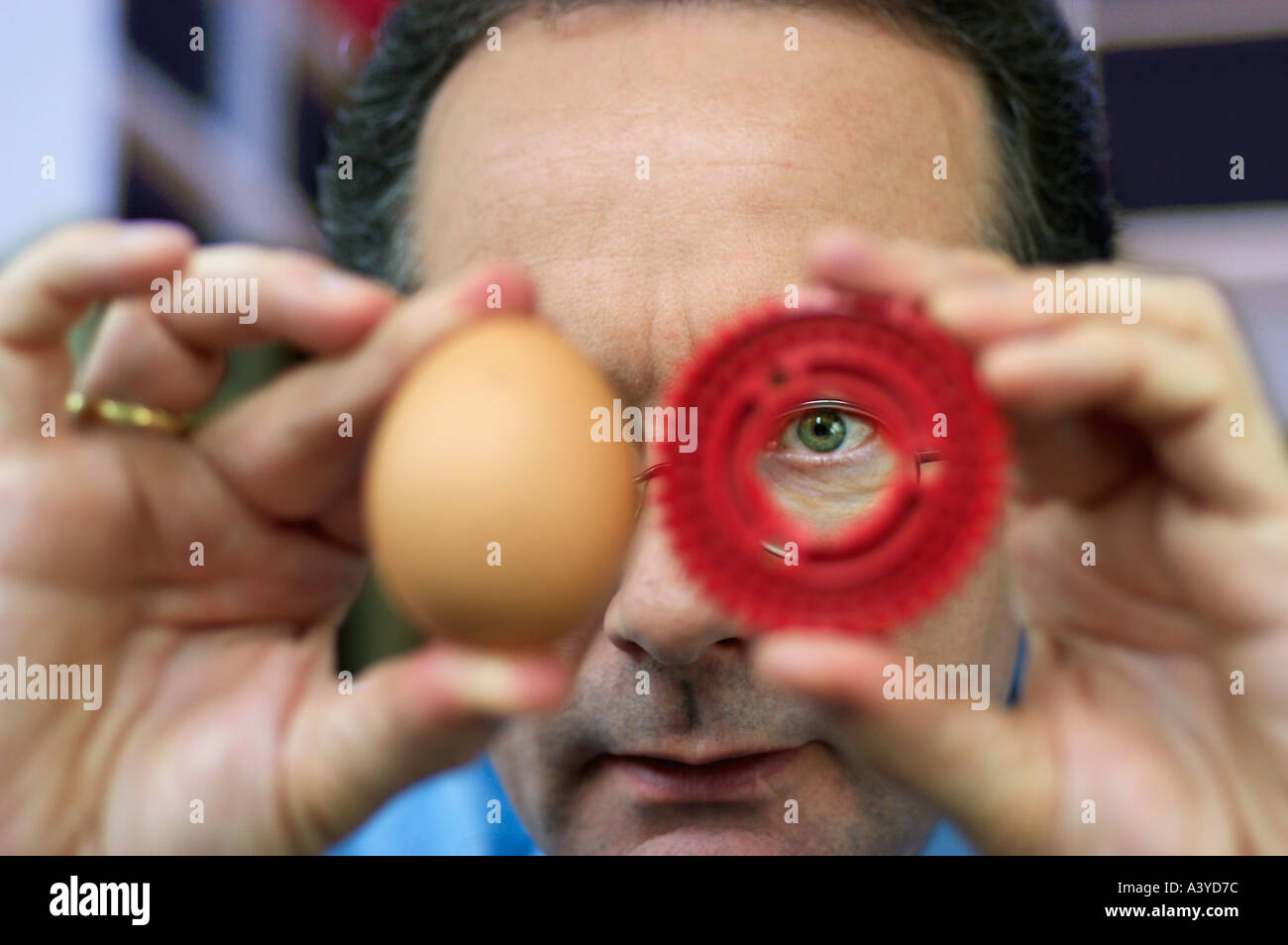 Nature and technology biological engineering Man holding egg nest to cog wheel Stock Photo