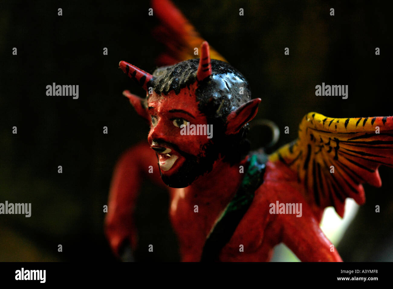 Devil figure playing a drum with wings on his back and a beard Stock Photo