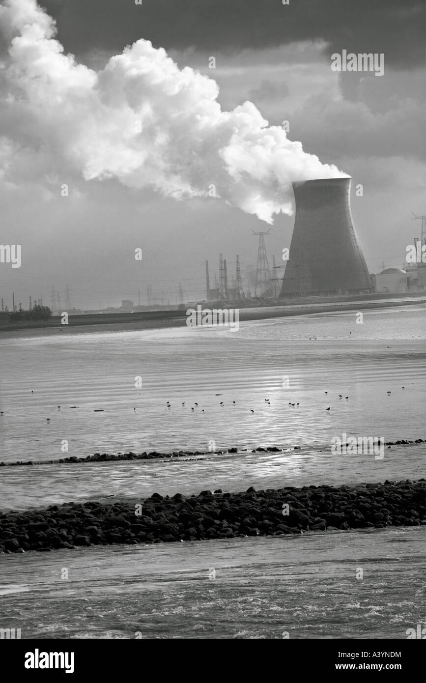 Nuclear power plant in Doel, Belgium. The Schelde; Scheldt; Escaut estuary in the foreground. Dramatic sky with vapor. Stock Photo