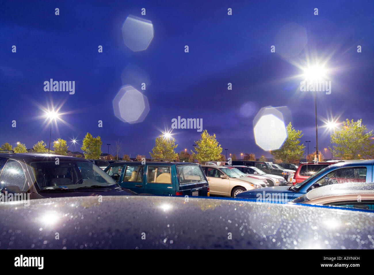 Supermarket parking lot, car park in the rain at night. Early autumn. Virginia USA. Lens flare caused by raindrops on the lens. Stock Photo