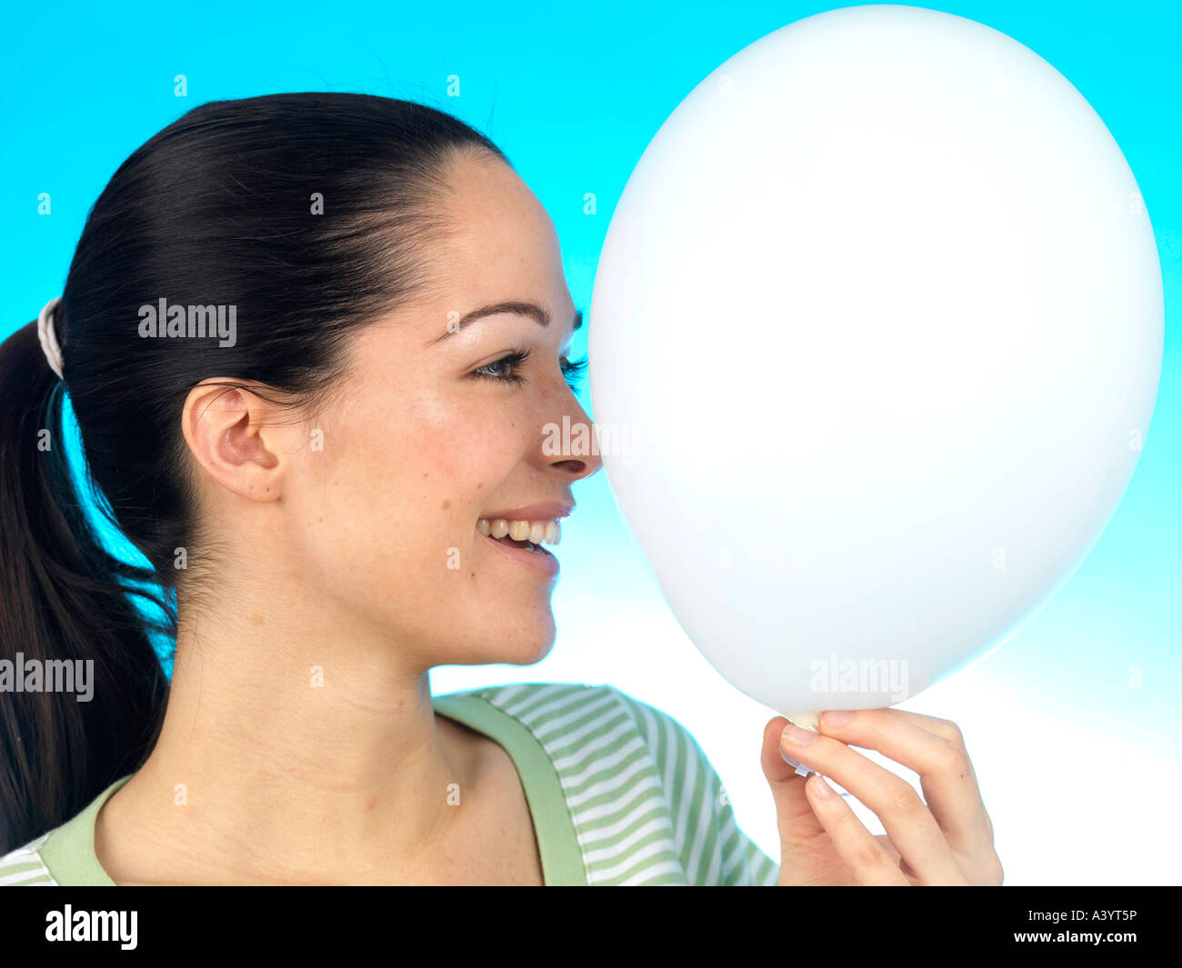 Young Woman Holding Coloured Inflated Balloons Against A Blue ...