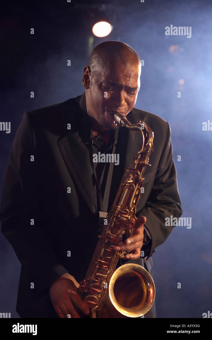 Jazz musician playing saxophone on smokey nightclub stage Stock Photo
