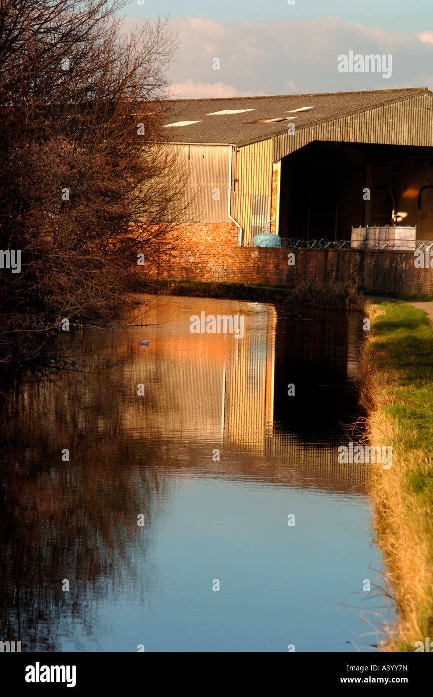 Factory Buildings Reflected In The Waters Of The Cauldon Canal,In Stoke-On-Trent,Staffordshire. Stock Photo