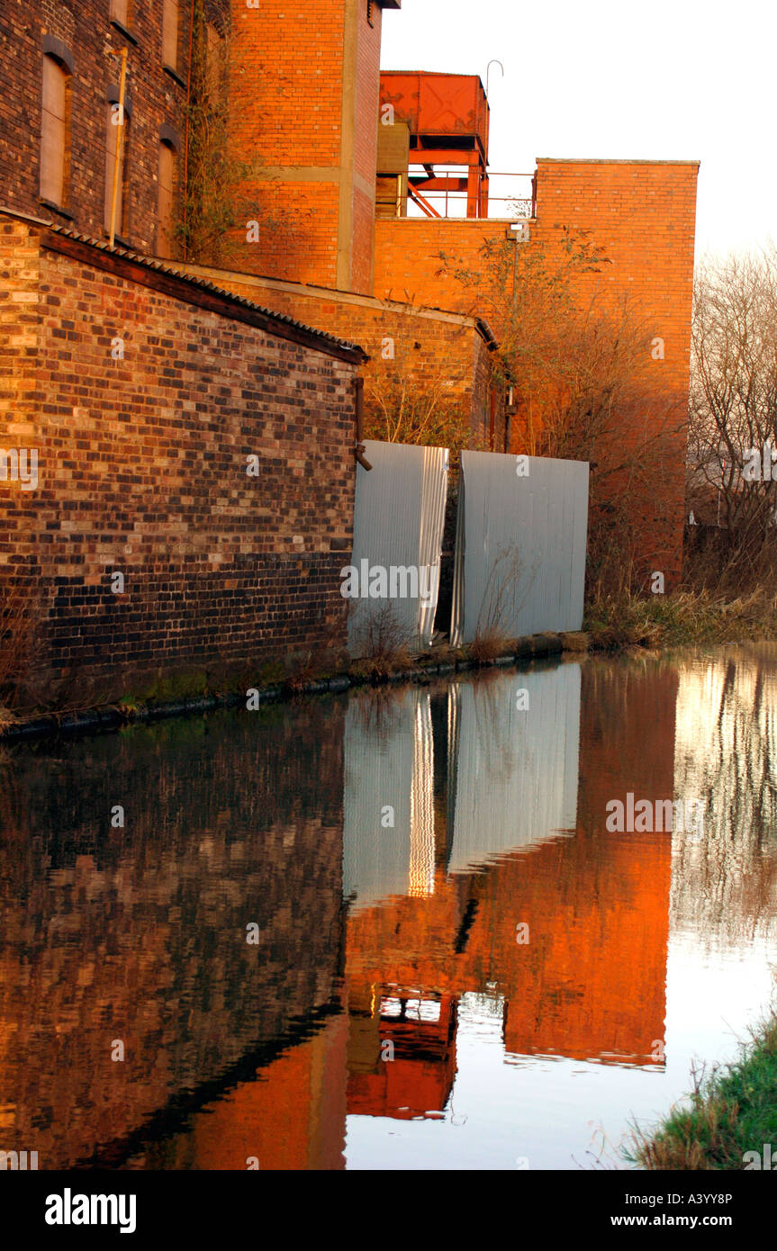 Empty Factory Buildings,Reflecting In The Waters Of The Cauldon Canal,In Stoke-On-Trent, Staffordshire,England. Stock Photo