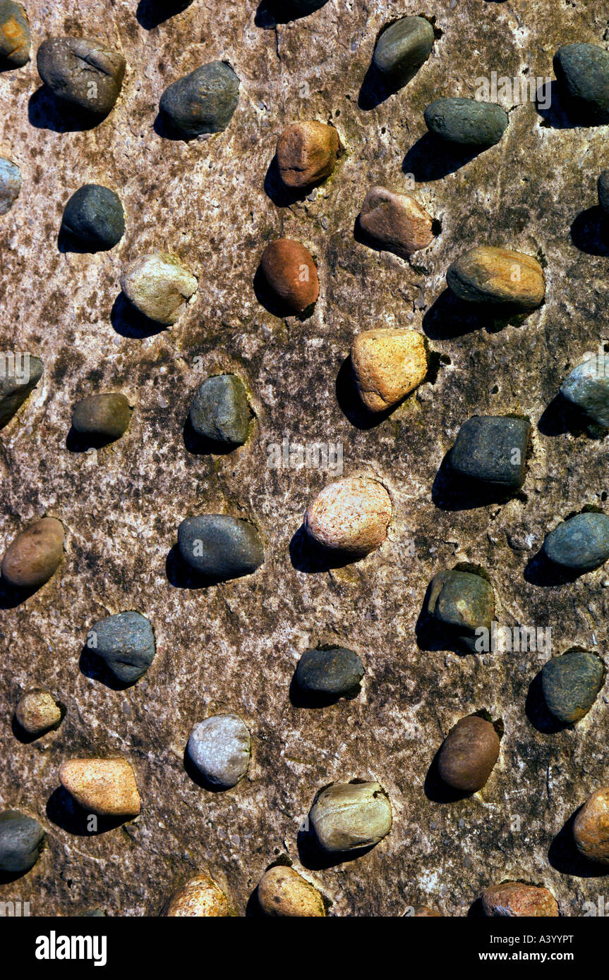 Stones Placed & Fixed Into Concrete,Producing Decorative Shapes & Patterns, On An Otherwise Bland Background. Stock Photo