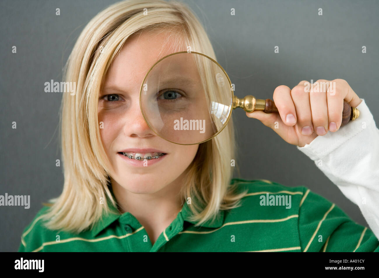 portrait of blonde boy holding magnifying glass Stock Photo
