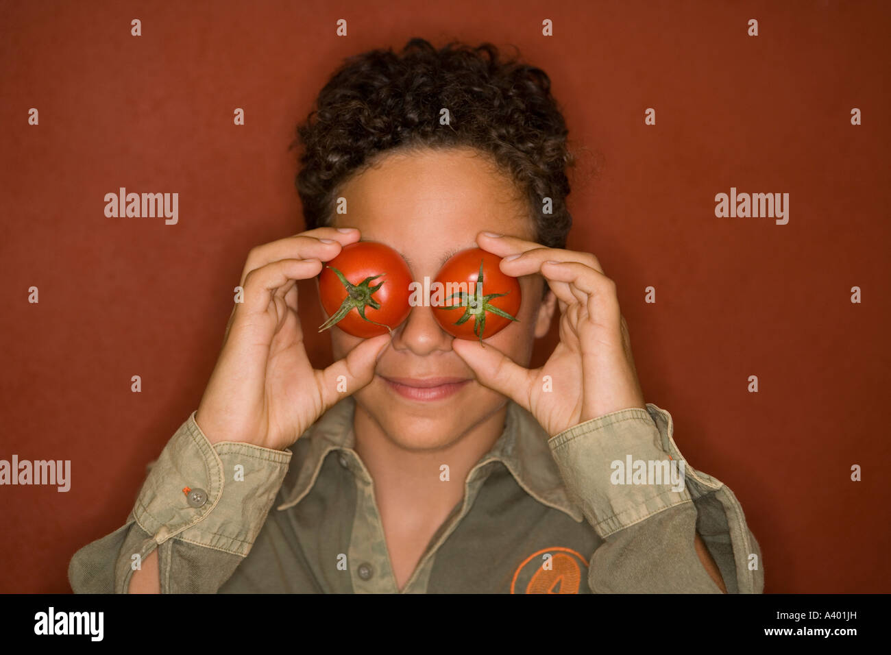 teenage boy covering eyes with tomatoes Stock Photo - Alamy