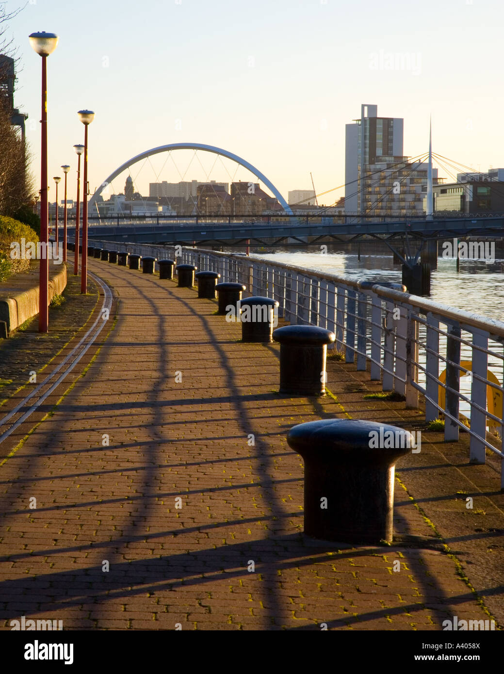 Early morning sunlight on River Clyde Walkway looking to new squinty footbridge Glasgow Scotland UK Stock Photo