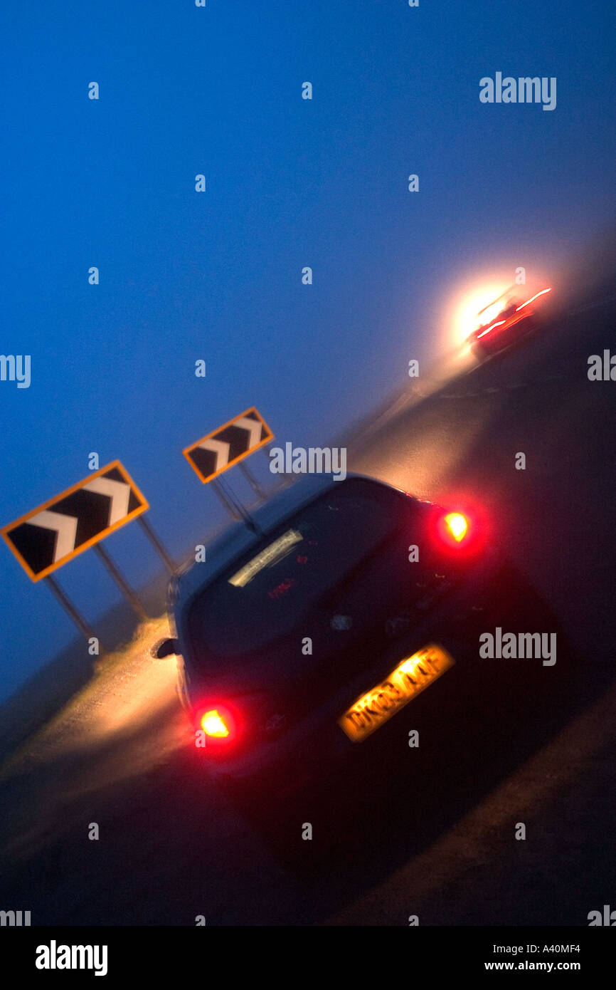 Angled shot of sports car and traffic on foggy night with blurred effect Stock Photo