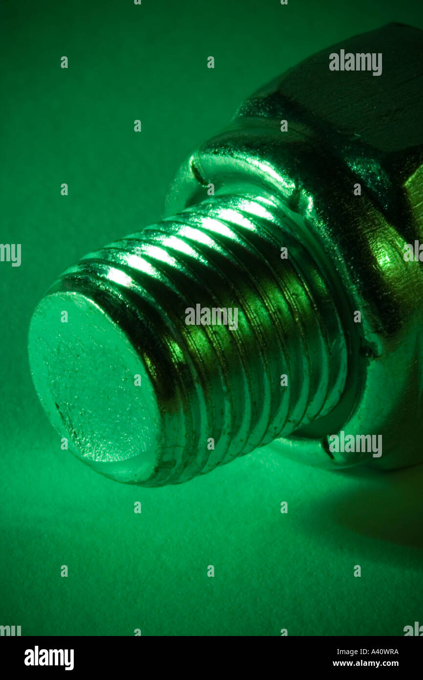 Threads of bolt protruding from nyloc locking nut, lit deep green Stock ...