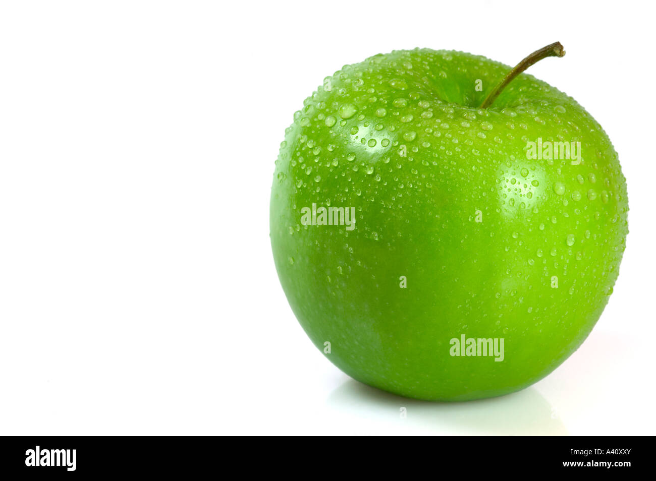 Green apple covered in water droplets isolated against a white background Stock Photo