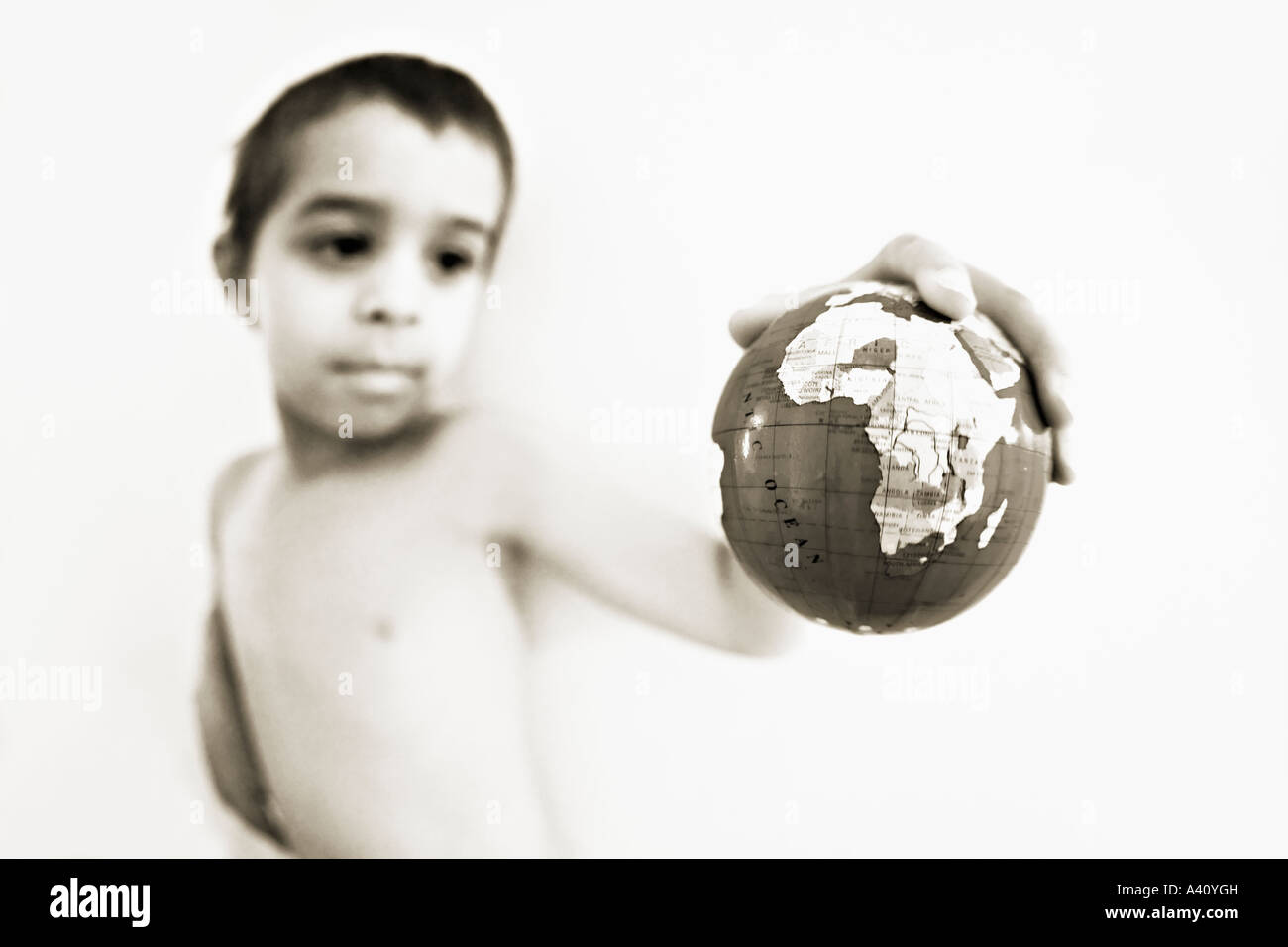 Boy holds globe in hand Stock Photo