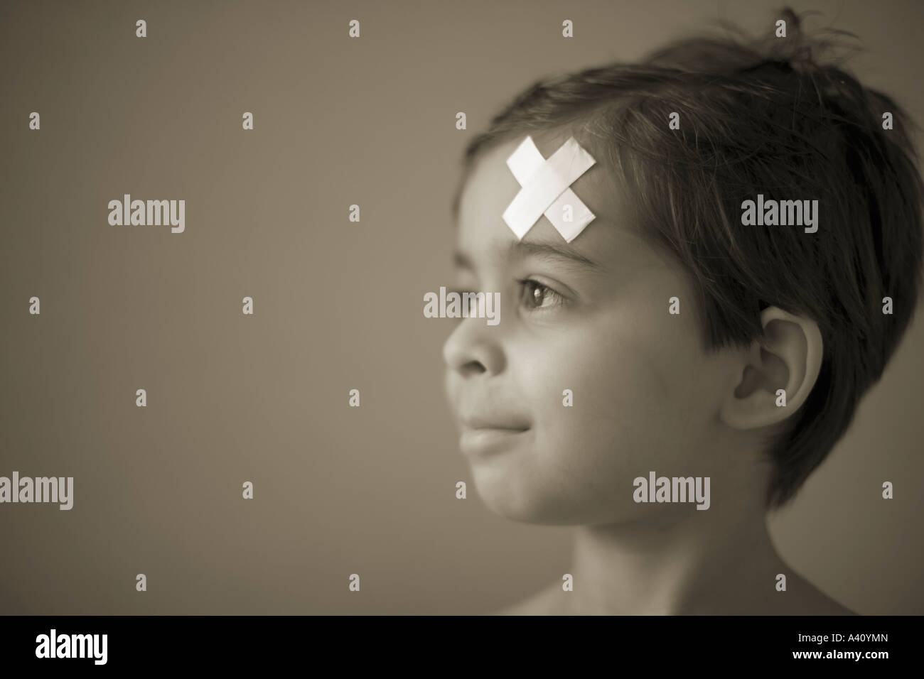 Boy with band aid stuck to forehead Stock Photo Alamy