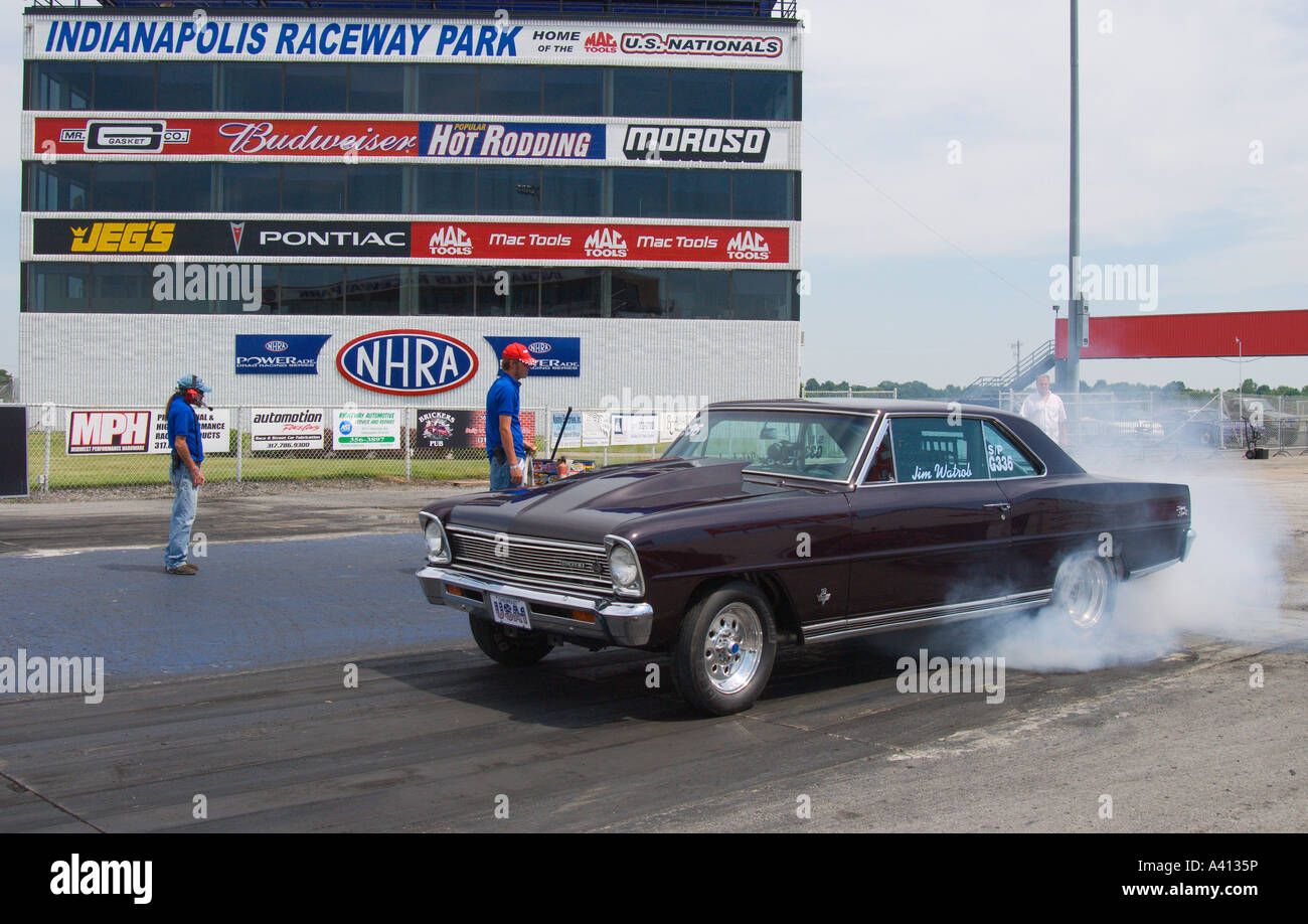 Chevrolet drag race car warming tires in a burn out before the race Stock Photo