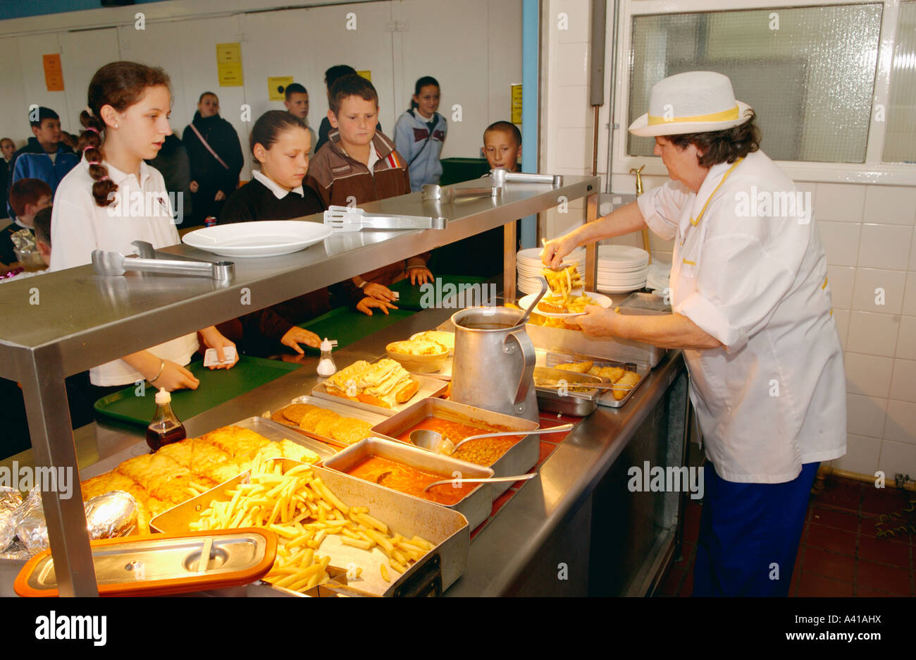 School pupils queue at hot counter waiting to be served by kitchen