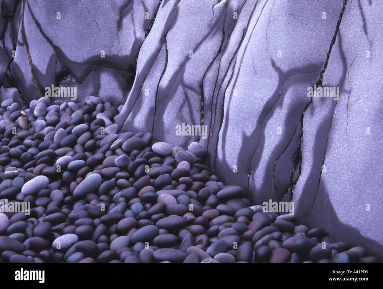 Smooth coloured granite pebbles and rocks on beach Hurlstone Point Somerset England Stock Photo