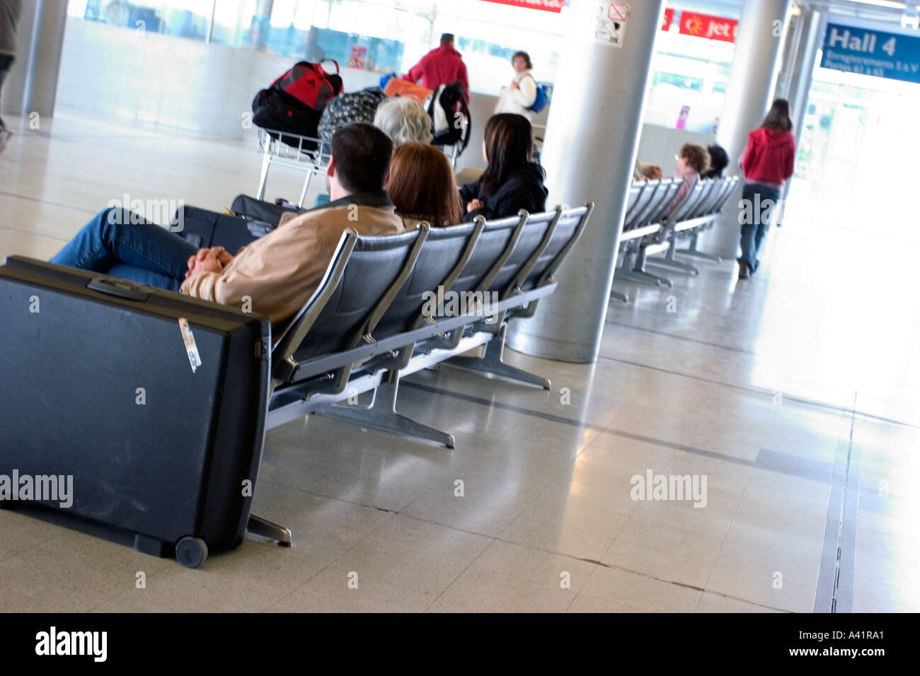 Travelers sitting and waiting on chairs and bench an airplane in nantes airport france Stock Photo