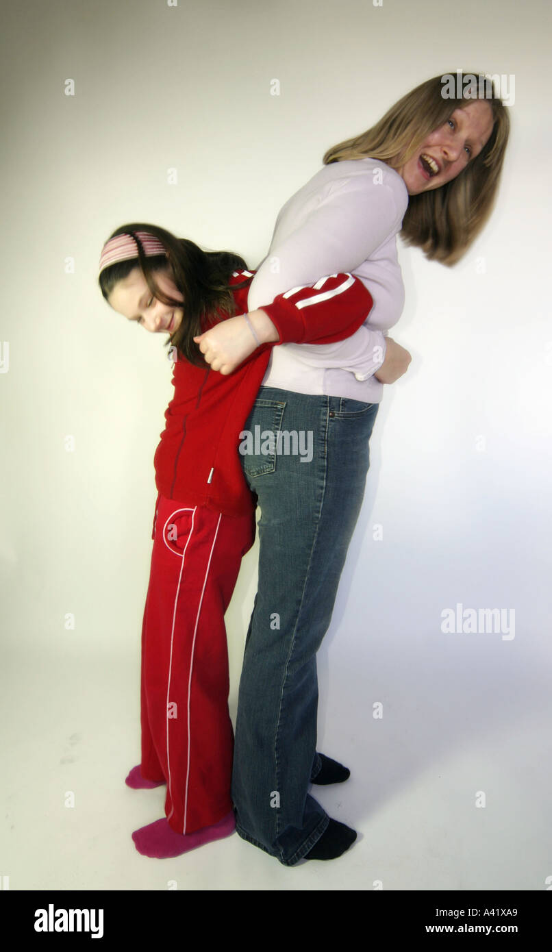 Young girl and young woman stretch and lift with arms locked Stock Photo