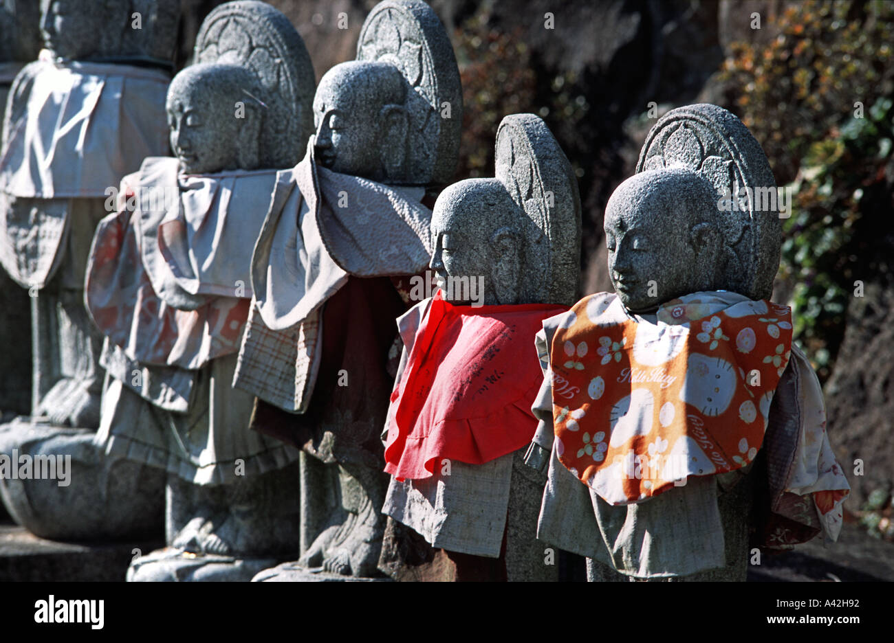 Stone carved mizo Jizo statues clothed in fabric bibs at Tsubosaka dera temple Nara prefecture Japan Historic temple Stock Photo