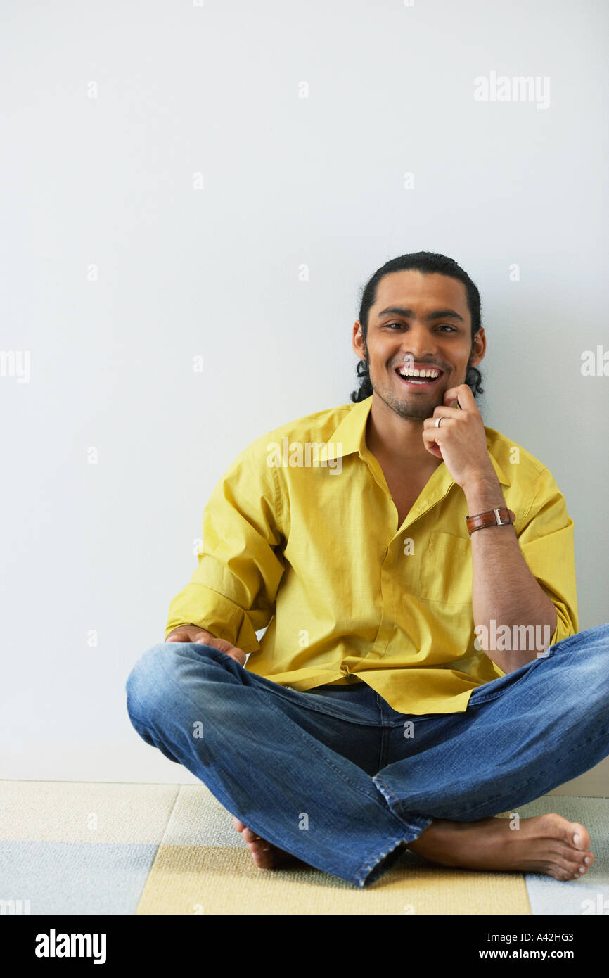Portrait of man sitting cross legged on floor laughing Stock Photo Alamy