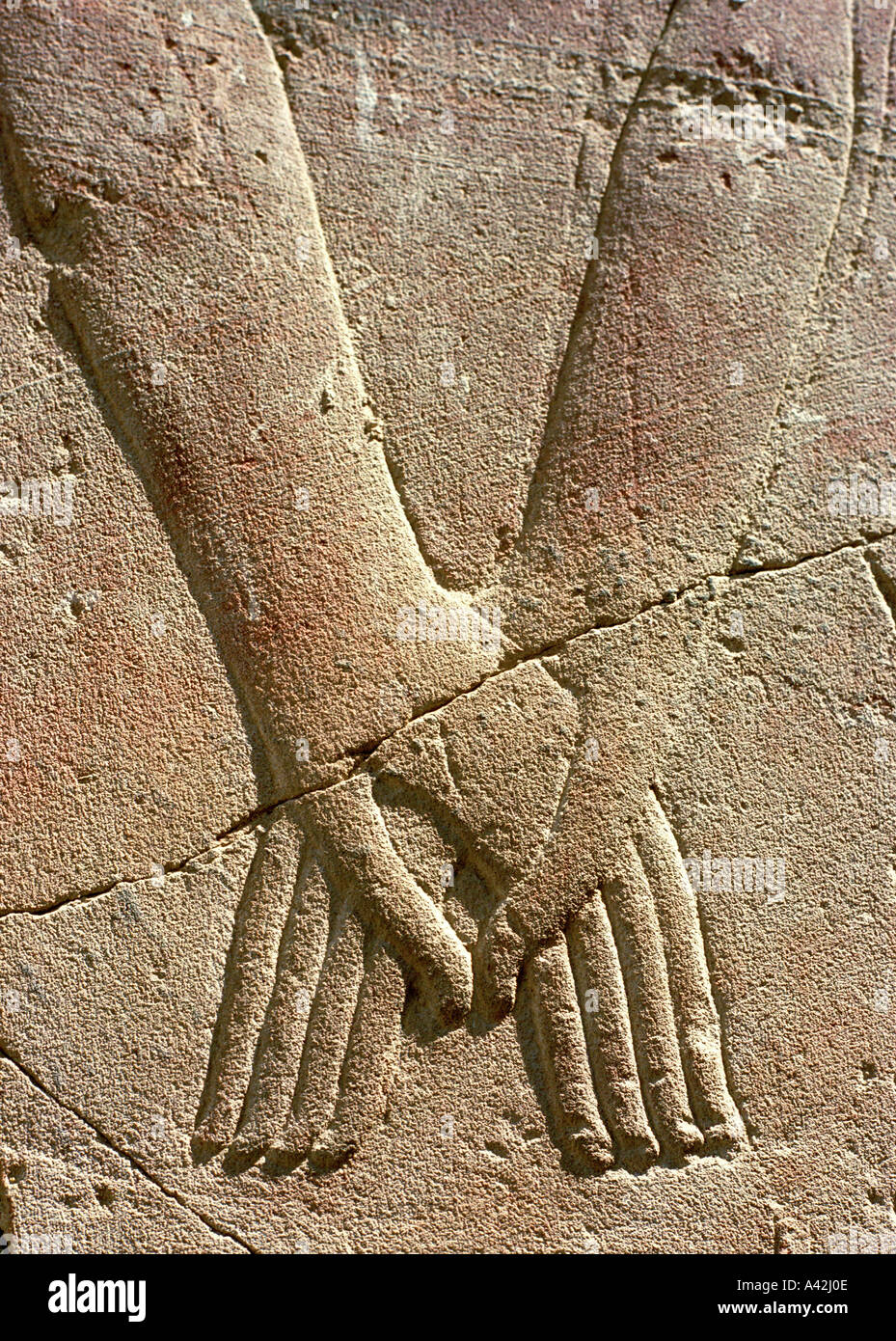 A relief sculpture on a wall of the great temple of Amun Ra at Luxor shows the Pharaoh and the god holding hands Stock Photo