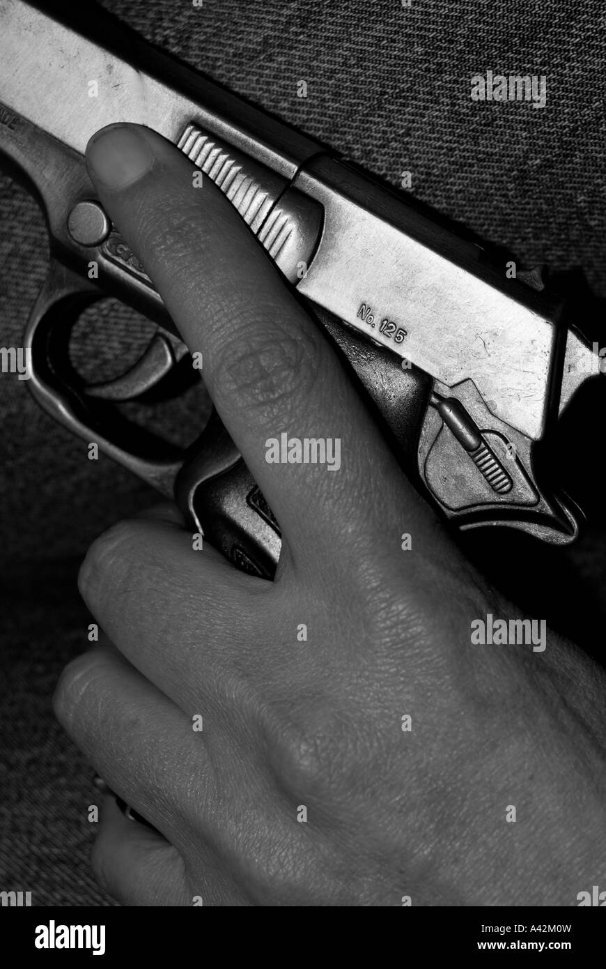 Teenage Hand holding a Hand Gun Stock Photo