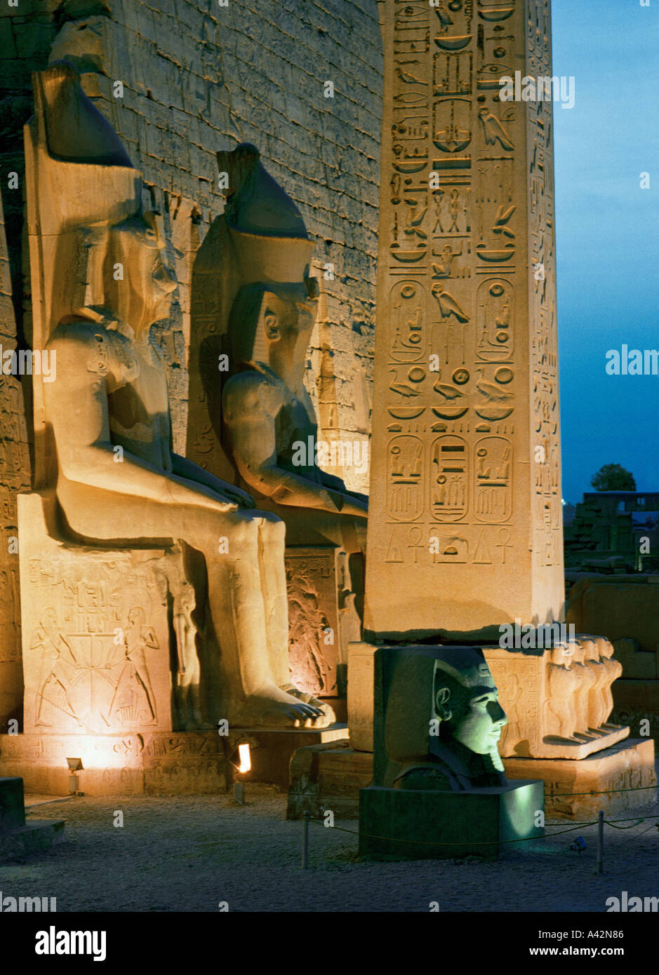 Temple of Luxor at dusk with colossal statues of Ramses ll flanking the ...