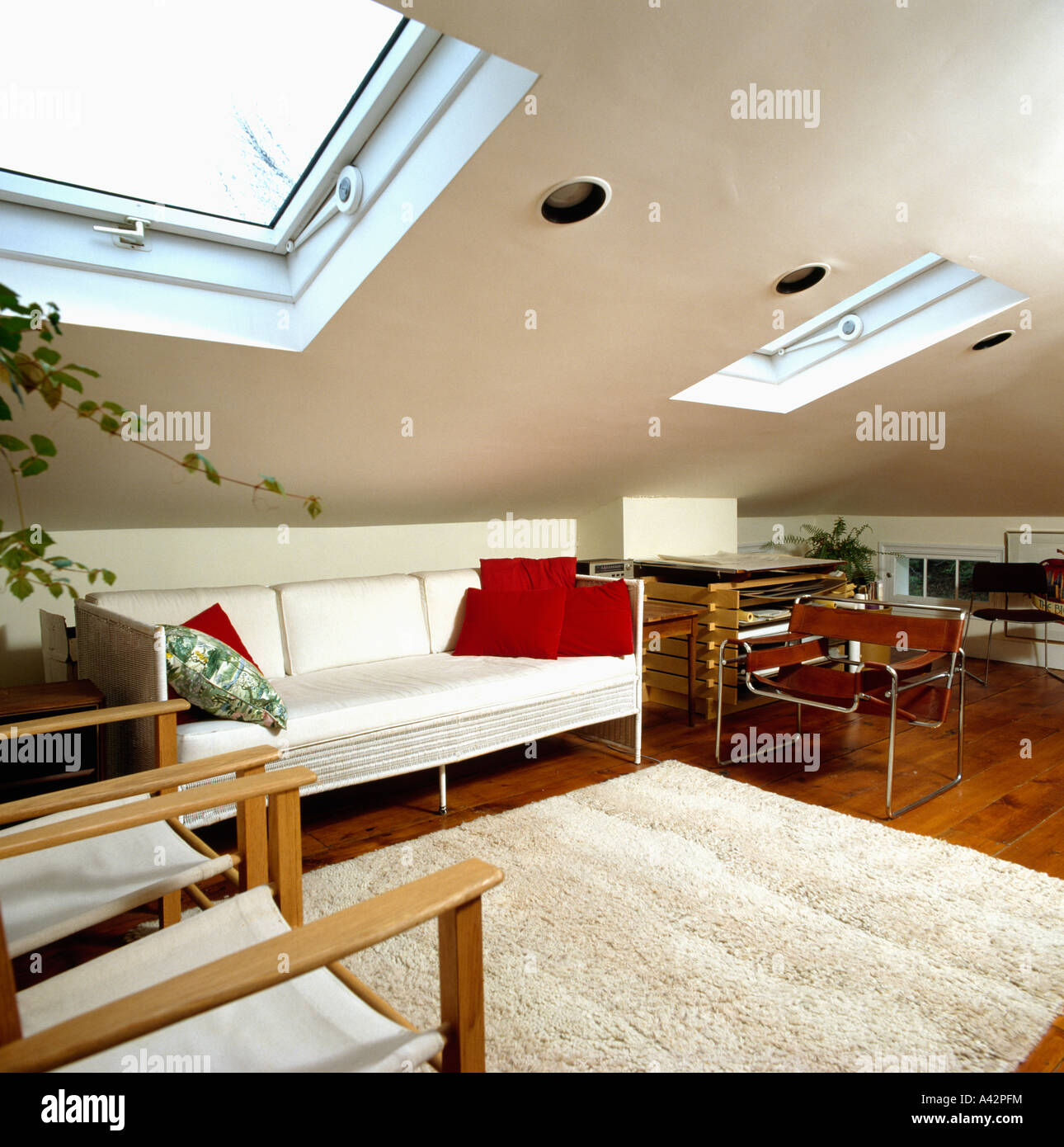 Velux windows and white sofa in modern loft conversion living room with sheepskin rug and Marcel Breuer Wassily chair Stock Photo