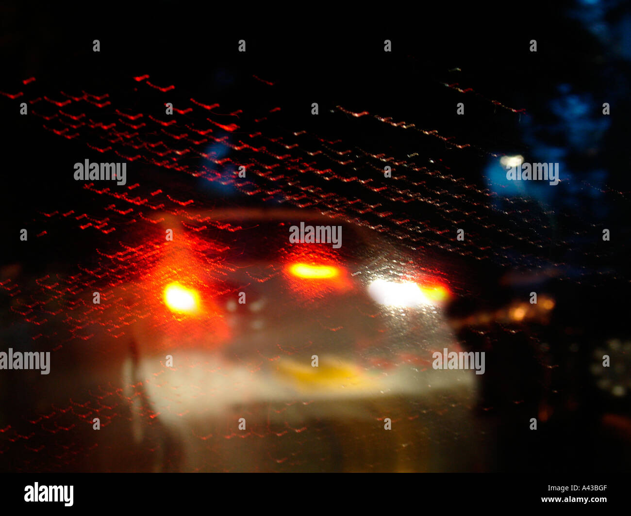 Blurred vision as seen through front car wind shield on a rainy night Stock Photo