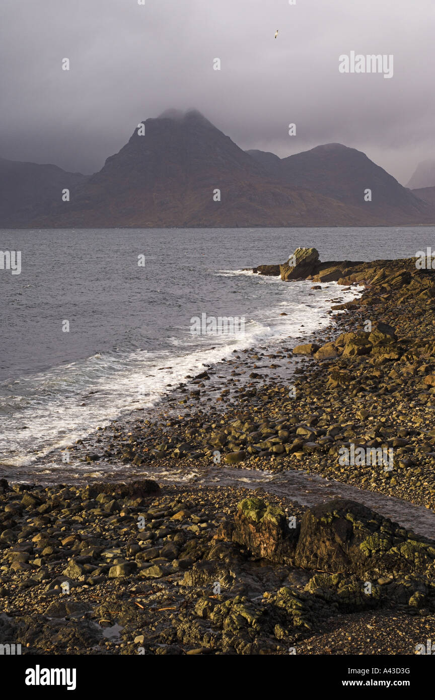 Pebble beach and cliff at Elgol, on the Isle of Skye, looking to Sgurr na Stri in the Black Cullin mountains. Stock Photo