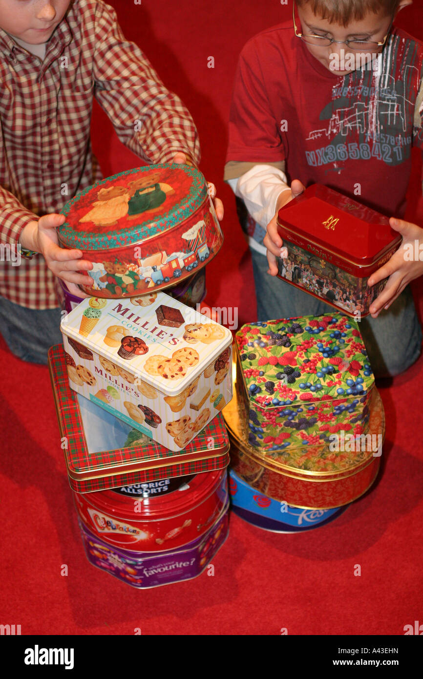 Two young children boys play with empty metal steel recyclable sweet