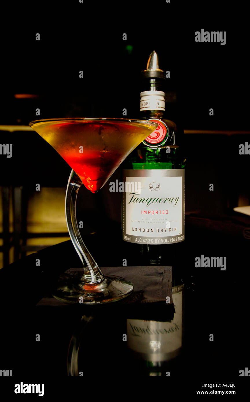 Cocktail glass filled with Tanqueray gin and Grenadine syrup in a bar
