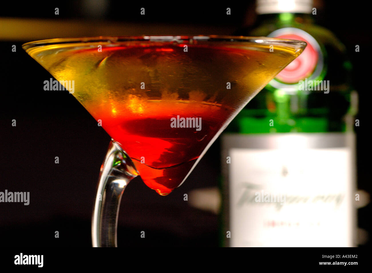 Cocktail glass filled with Tanqueray gin and Grenadine syrup in a bar